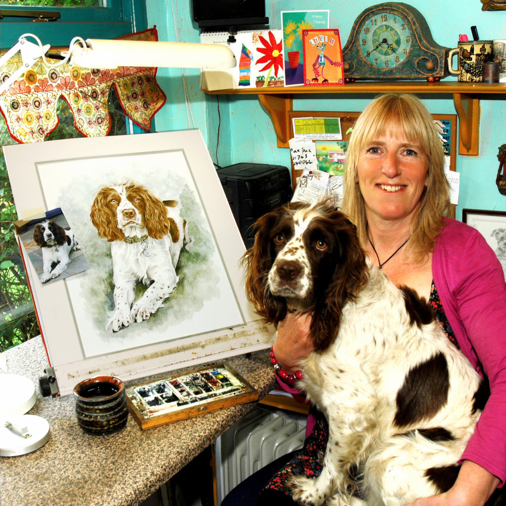 Christine Varley sitting with her Springer Spaniel Molly and her portrait